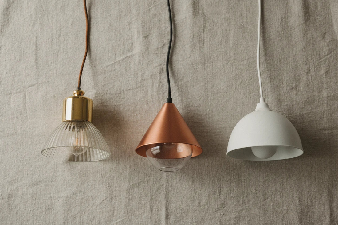 Three pendants laid out on linen showing clear differences in build quality