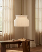 Aureline luxe gold ribbed glass pendant. Lit. In a kitchen setting. - Luxe Gold - Cased White