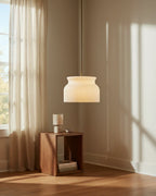 Aureline luxe gold ribbed glass pendant. Lit. In a kitchen setting.