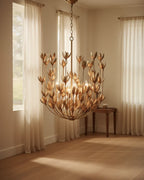Aureline tiered bloom chandelier in burnished gold, lit in a living room setting - Burnished Gold