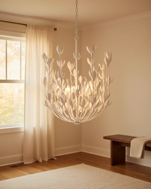 Aureline tiered bloom chandelier in burnished gold, lit in a living room setting - Plaster White