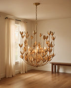 Aurelis tiered petal chandelier in burnished gold, lit, hanging in a living room - Burnished Gold