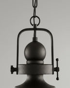 Industrial-style pendant light with a matte black iron frame and clear glass bowl shade lit over a marble kitchen island - detail 1