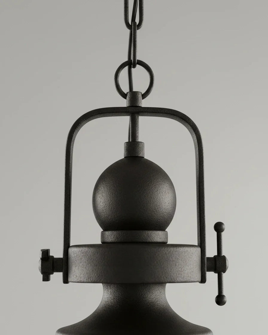 Industrial-style pendant light with a matte black iron frame and clear glass bowl shade lit over a marble kitchen island - detail 1