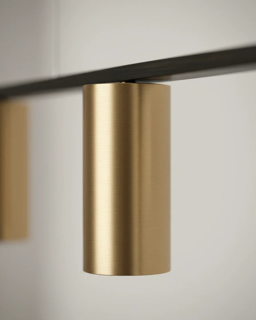 Modern linear island pendant with cylindrical gold and black shades on a horizontal bar, lit over a marble counter. - detail 2