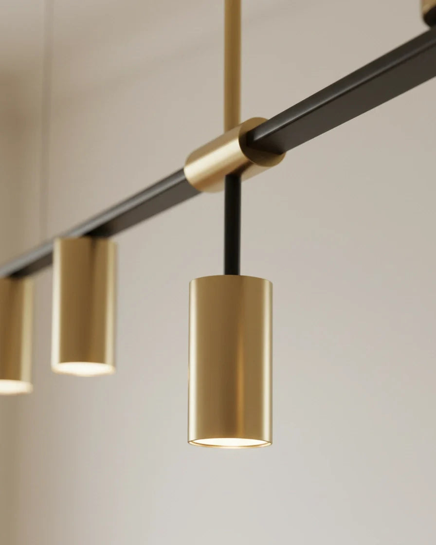 Modern linear island pendant with cylindrical gold and black shades on a horizontal bar, lit over a marble counter. - detail 4