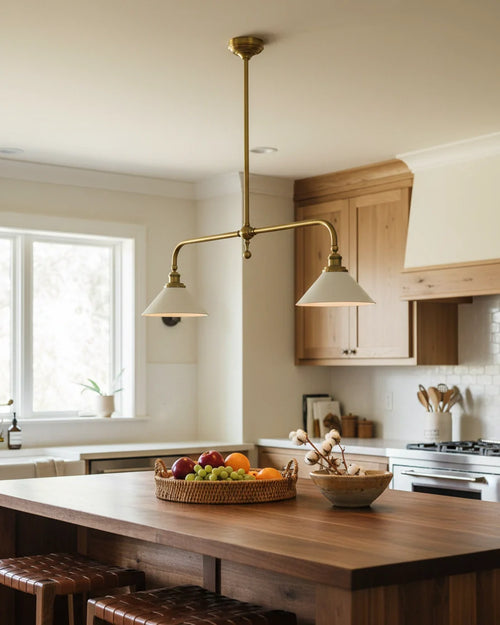 Two-light linear pendant with brass finish and conical shades, illuminated